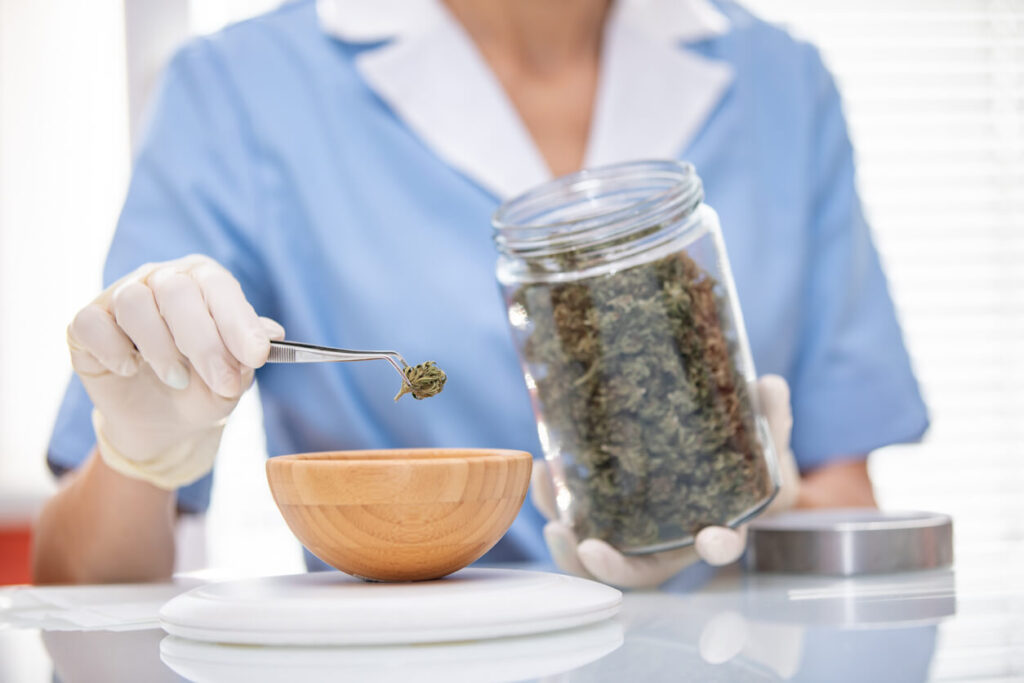 Woman putting cannabis bud into a bowl